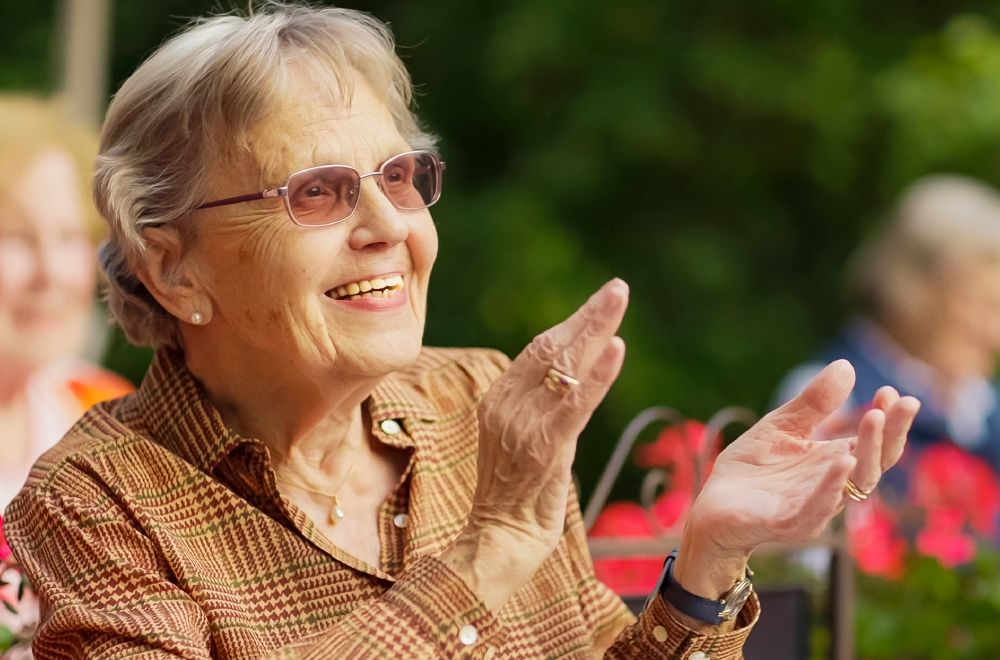 Klatschende Bewohnerin bei einem Konzert im WohnGut Parkresidenz Bad Honnef