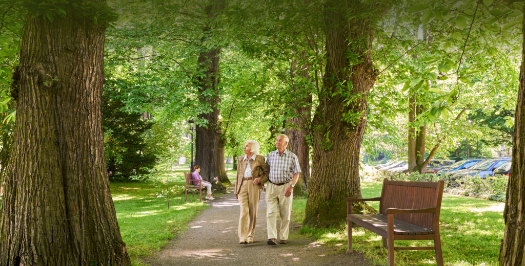 Paar spaziert Hand in Hand durch einen Allee im WohnGut Parkresidenz Bad Honnef