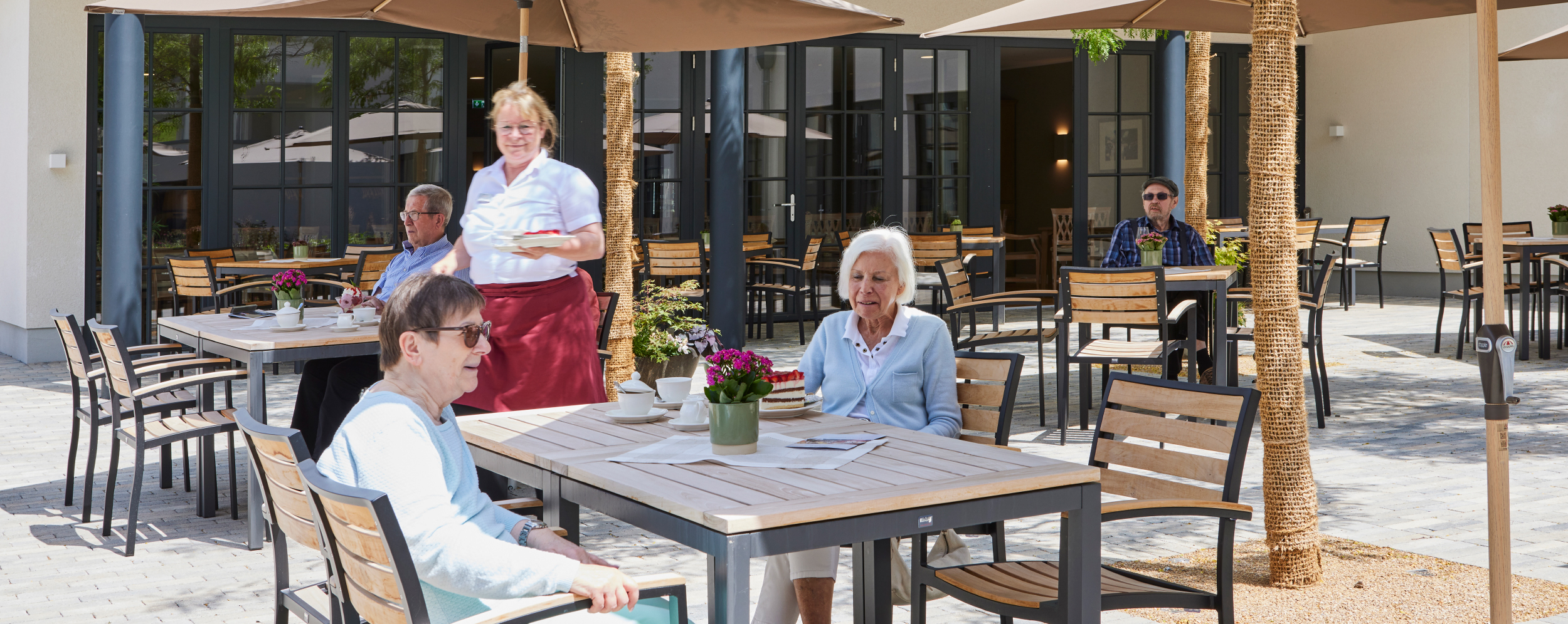 Bewohner auf der Terrasse bei Kaffee und Kuchen im WohnGut Saalhausen