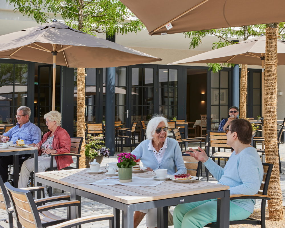 Bewohner auf der Terrasse bei Kaffee und Kuchen im WohnGut Saalhausen