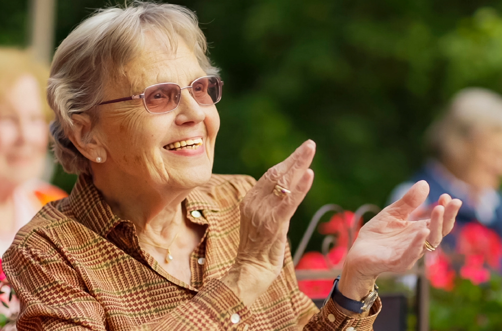 Bewohnerin klatschend bei einem Konzert