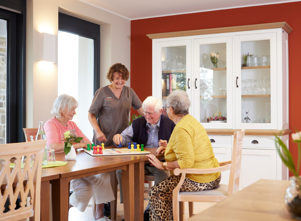 Bewohner spielen Mensch-ärger-dich-nicht im Gemeinschafts-Wohnen im WohnGut Osterseifen