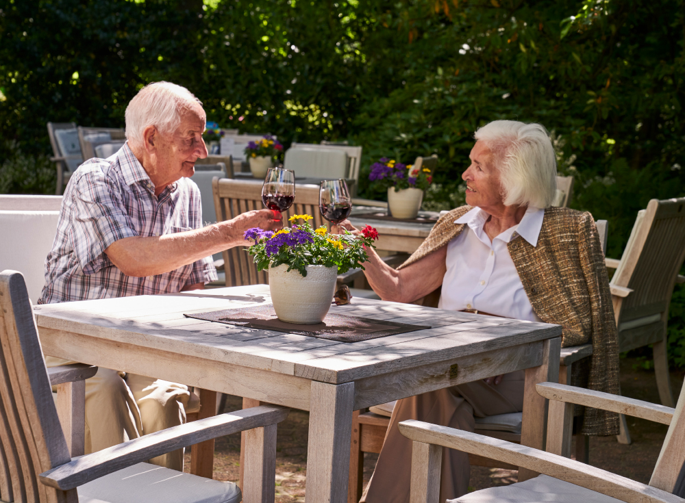 Bewohner stoßen auf der Terrasse im WohnGut Parkresidenz Bad Honnef mit Wein an