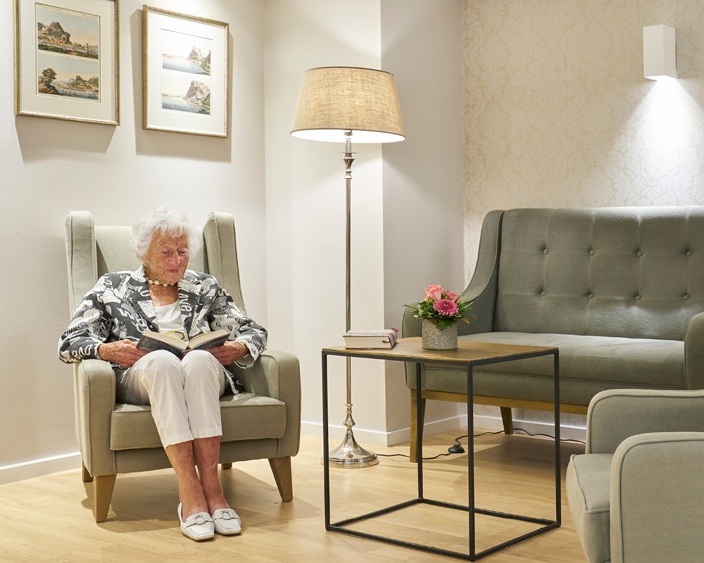 Bewohnerin im gemütlichen Sitzbereich der WohnGut Parkresidenz Bad Honnef