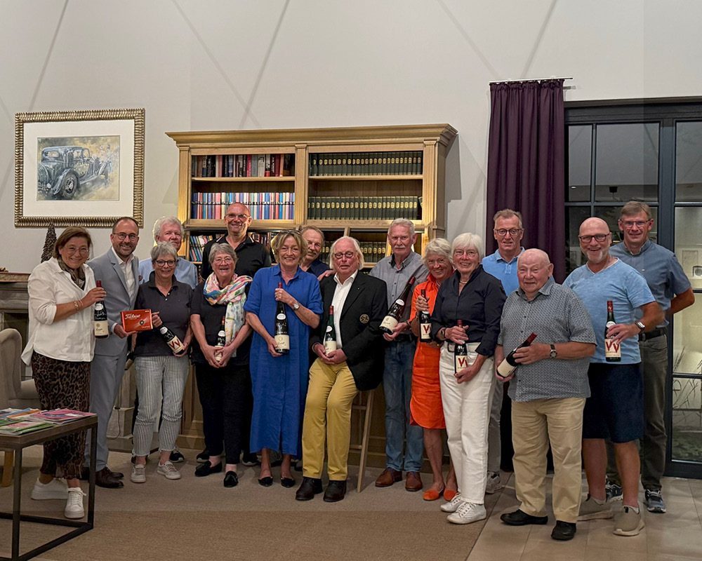 Gruppenfoto der Bewohner mit Weinflaschen nach einem Golfturnier im WohnGut Saalhausen