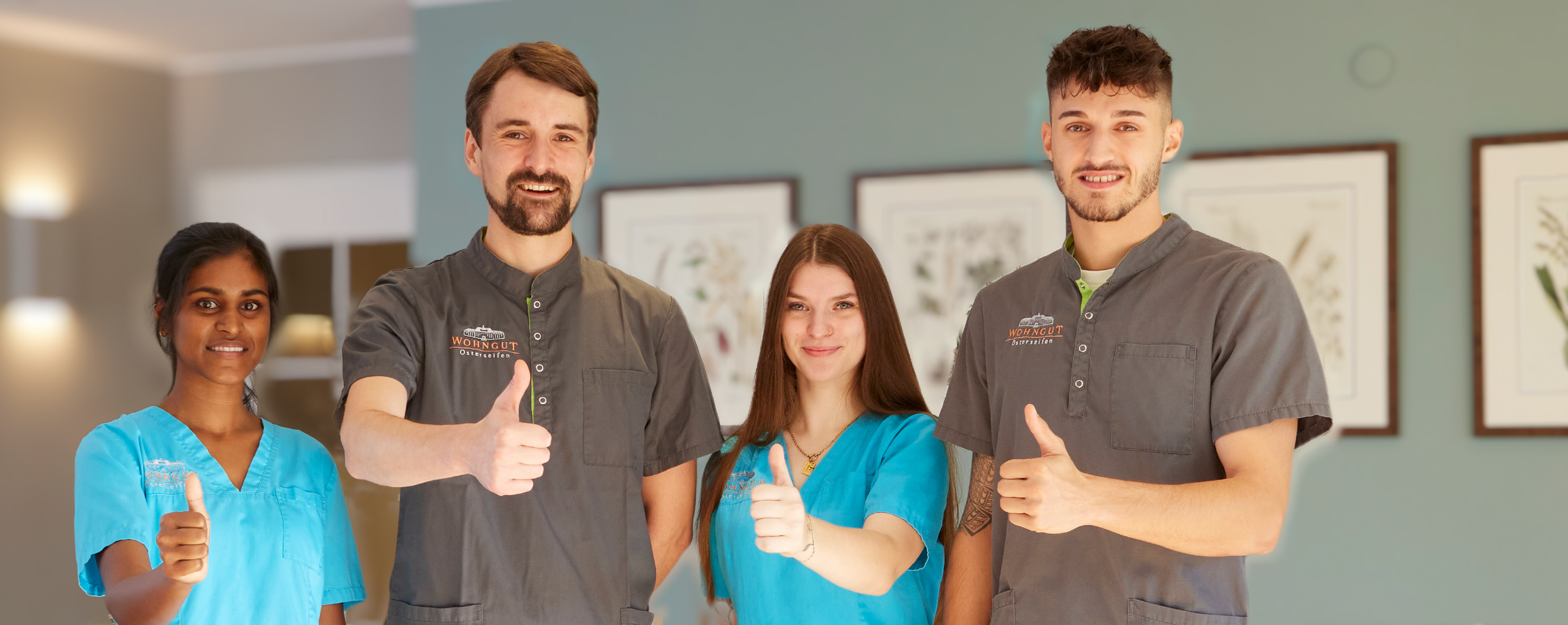 Glückliche Mitarbeiter im WohnGut-Team zeigen den Daumen nach oben