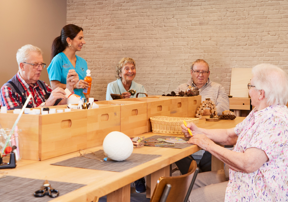 Pflegekraft und Bewohner beim Handwerken und Basteln