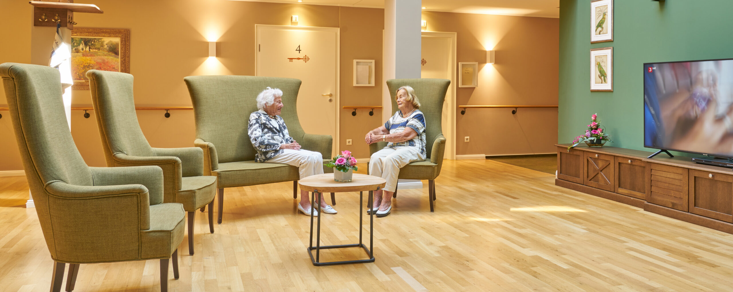 Stilvolles Ambiente in der Parkresidenz - 2 Bewohnerinnen sitzen im Atrium